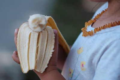 Close-up of child holding banana