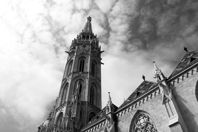 Low angle view of clock tower against cloudy sky