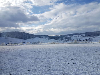 Scenic view of winter landscape against cloudy sky