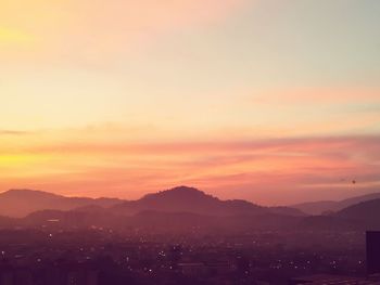 Scenic view of silhouette mountains against romantic sky at sunset