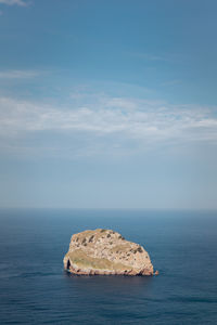 Scenic view of rocks in sea against sky