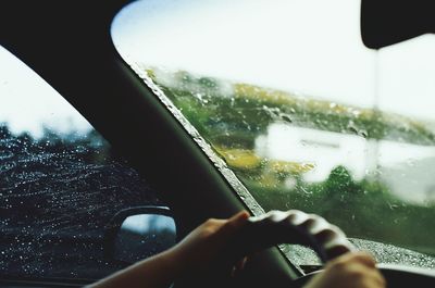 Close-up of hand holding car window