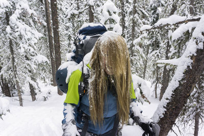 Young female hiker covered with snow while hiking on mountain