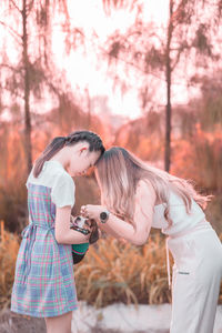 Side view of young woman standing in park