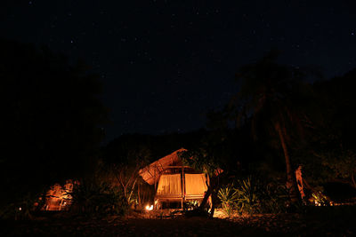 Illuminated hut in dark against sky at night