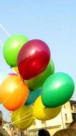 Low angle view of balloons against blue sky