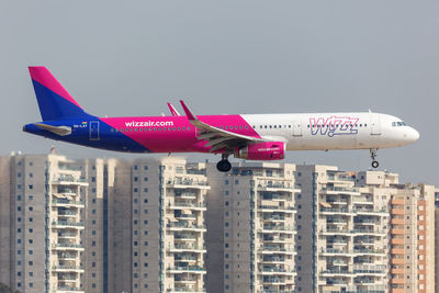 Low angle view of airplane flying in city against sky