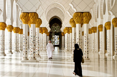 Rear view of people walking in temple building