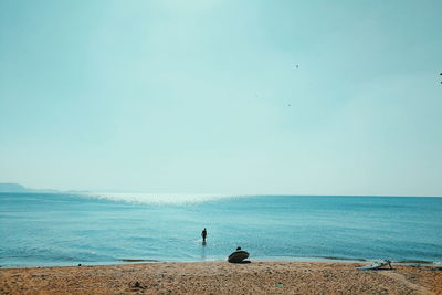 Man standing on beach against clear sky