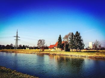 Scenic view of calm lake against clear blue sky