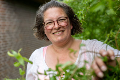 Portrait of young woman holding plant