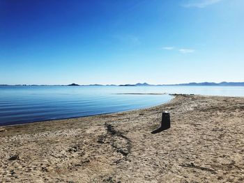 Scenic view of beach against blue sky