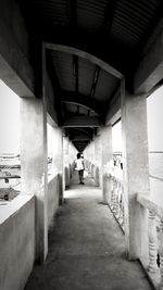 Rear view of man walking under bridge