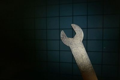 Close-up of wrench against wall