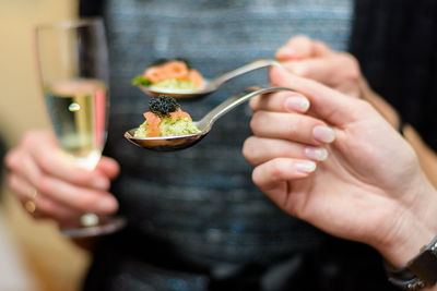 Close-up of hands holding food and drink