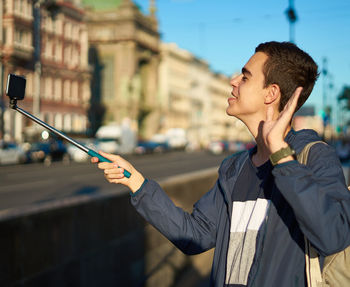Man taking selfie while standing on street in city