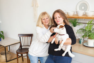 Portrait of young woman with dog at home