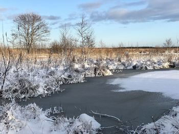 Frozen lake against sky during winter