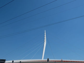 Low angle view of modern bridge against clear blue sky