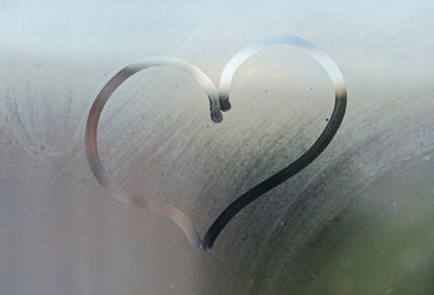 Heart, finger drawing on a foggy window