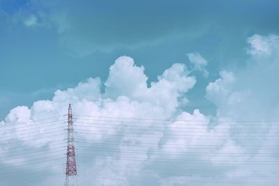 Low angle view of electricity pylon against blue sky