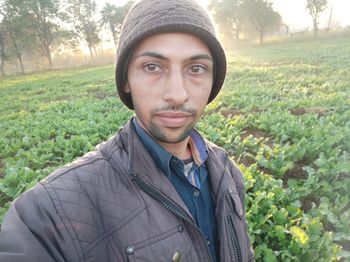 Portrait of young man standing against plants