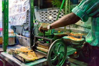 Midsection of man using machinery at market stall