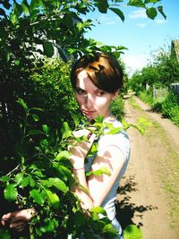 Close-up of young woman against plants