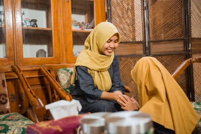 Portrait of young woman sitting on sofa at home