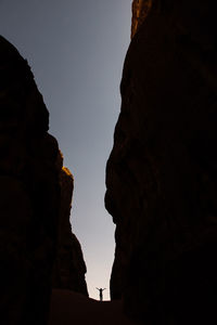 Low angle view of silhouette rock formations against sky