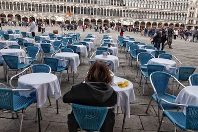 Rear view of people sitting at sidewalk cafe