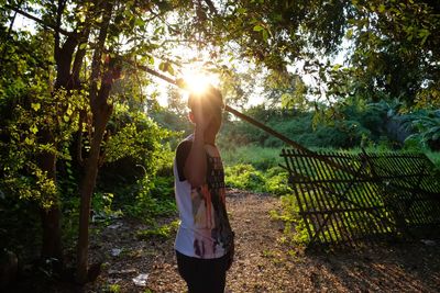 Full length of woman standing by tree