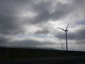 View of wind turbine against cloudy sky