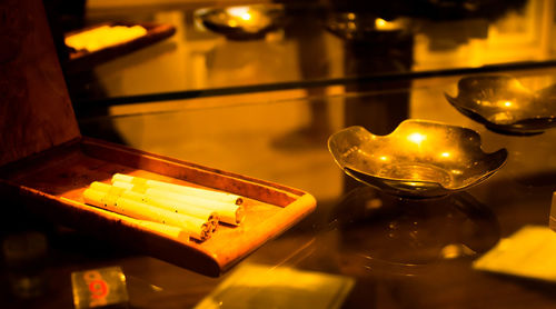 Close-up of cigarettes with ashtrays on table