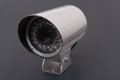 Close-up of security camera on black wall