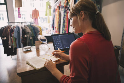 Owner working while sitting at desk in thrift store