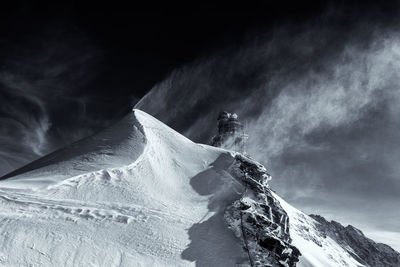 Low angle view of snowcapped mountain against sky