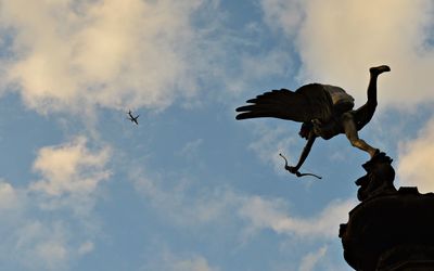 Low angle view of birds flying against sky