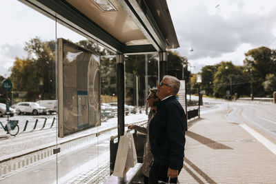 Senior couple looking at timetable at bus stop