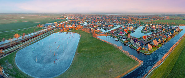 Aerial view on the village koudum with the ice rink in friesland the netherlands at sunset in winter
