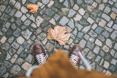 Low section of woman standing on footpath