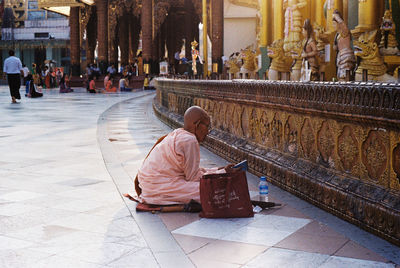 Rear view of people sitting outside temple