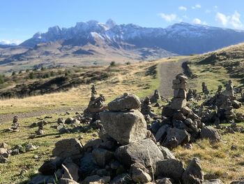 Stack of rocks on landscape against mountain range