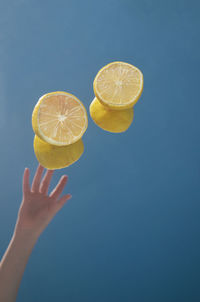 Midsection of woman holding ice cream against blue background