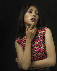 A beautiful woman with a red shirt and a black background with strong contrast