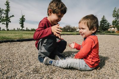 Siblings sitting on land