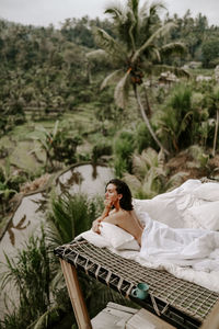 Woman lying on mattress and looking at view