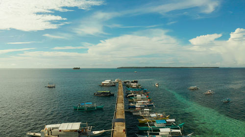 Tourist boats moored to a long pier on a tropical island, general luna, siargao.