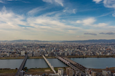 High angle view of river by buildings in city against sky