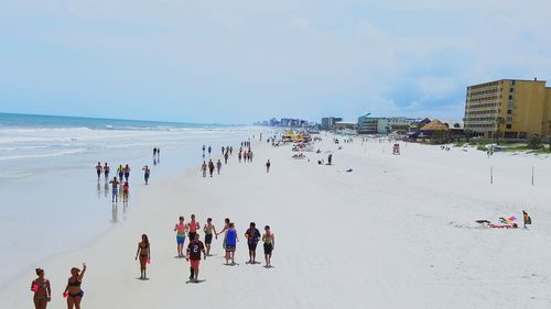 High angle view of people at beach against cloudy sky on sunny day in city